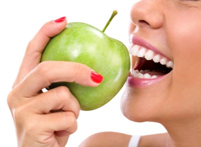 Frau beisst in einen grnen Apfel