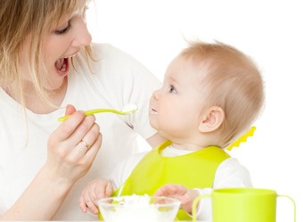 Mama füttert Kind mit Löffel
