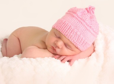 Nacktes Baby mit rosa Wollmuetze
