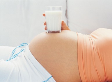 Schwangere mit Milchglas auf dem Bauch