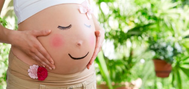 Schwangere mit Smiley auf dem Babybauch