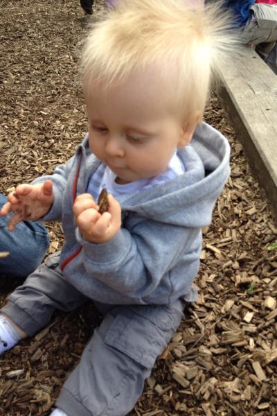 Bild zu Guckt mal Liam sitzt auf Rindenmulch und inspiziert ihn :) - Forum für August - Mamis