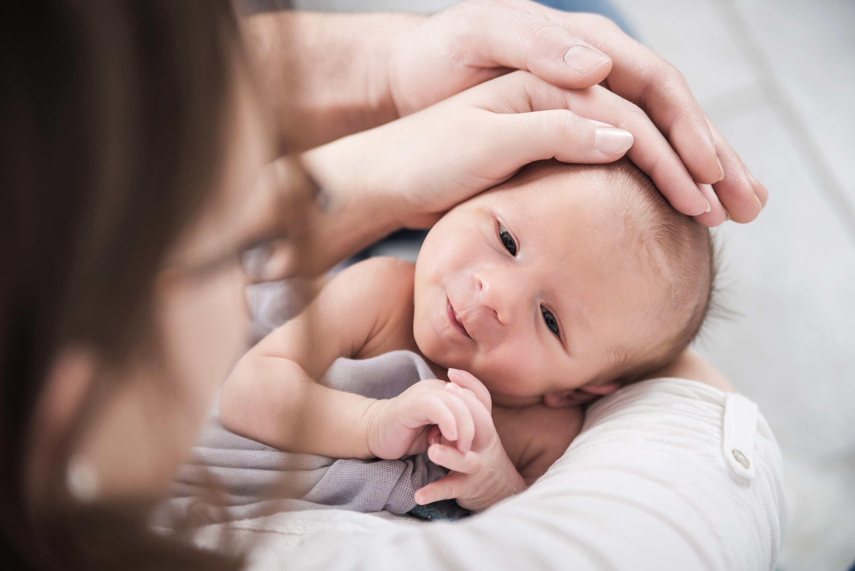 Baby mit Haenden auf dem Kopf