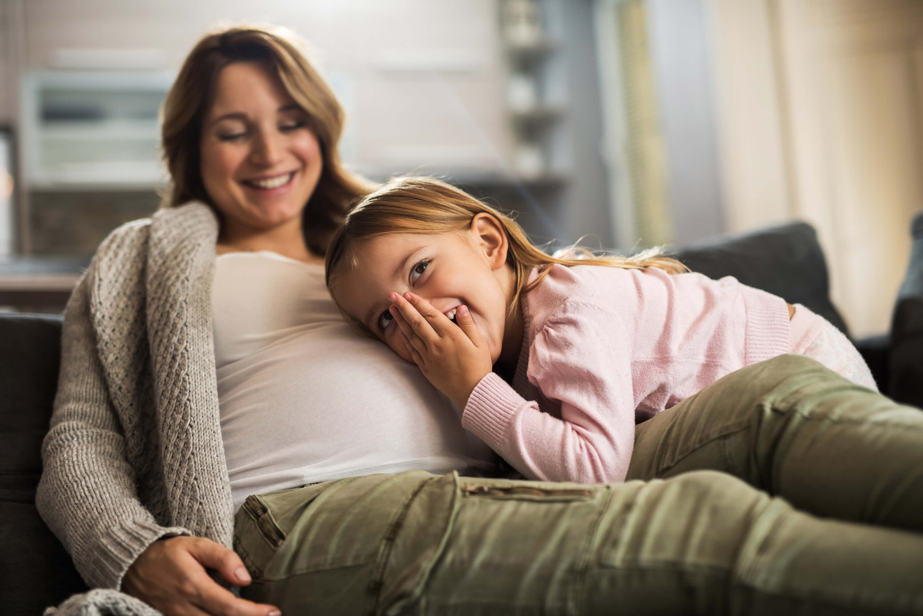 maedchen mit kopf an mamas babybauch