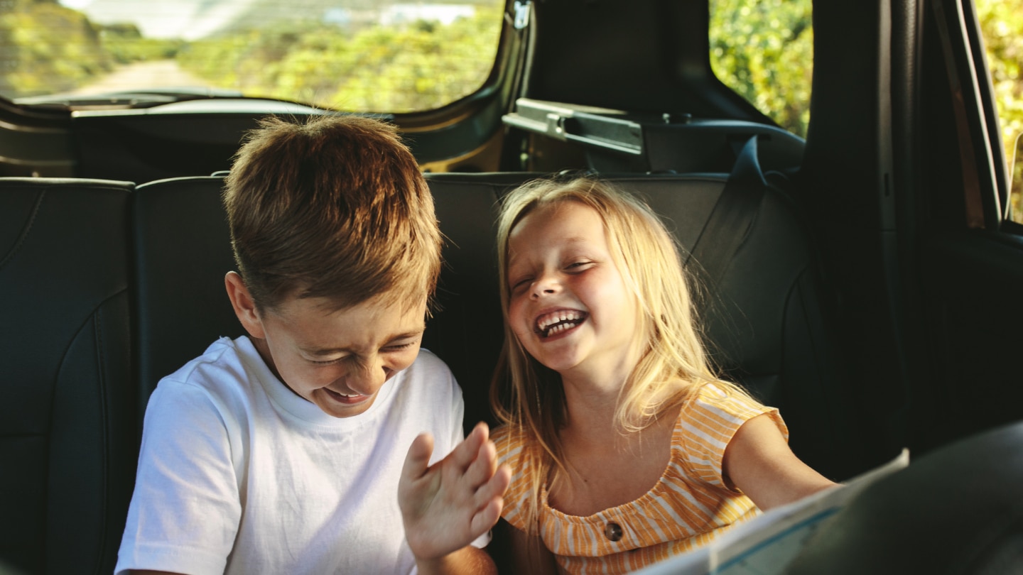 zwei kinder albern im auto 