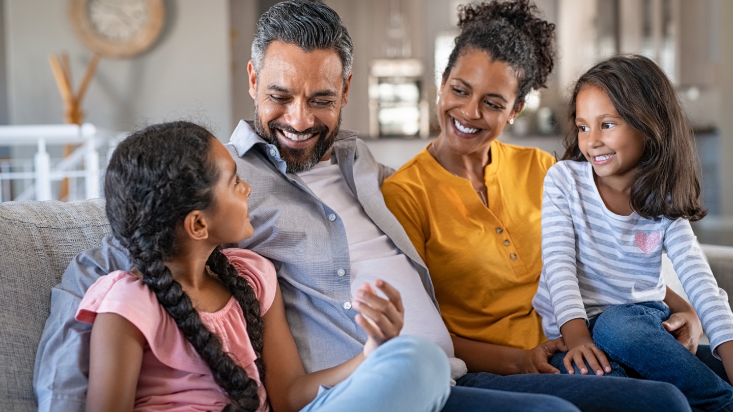 mutter vater und zwei töchter auf dem sofa