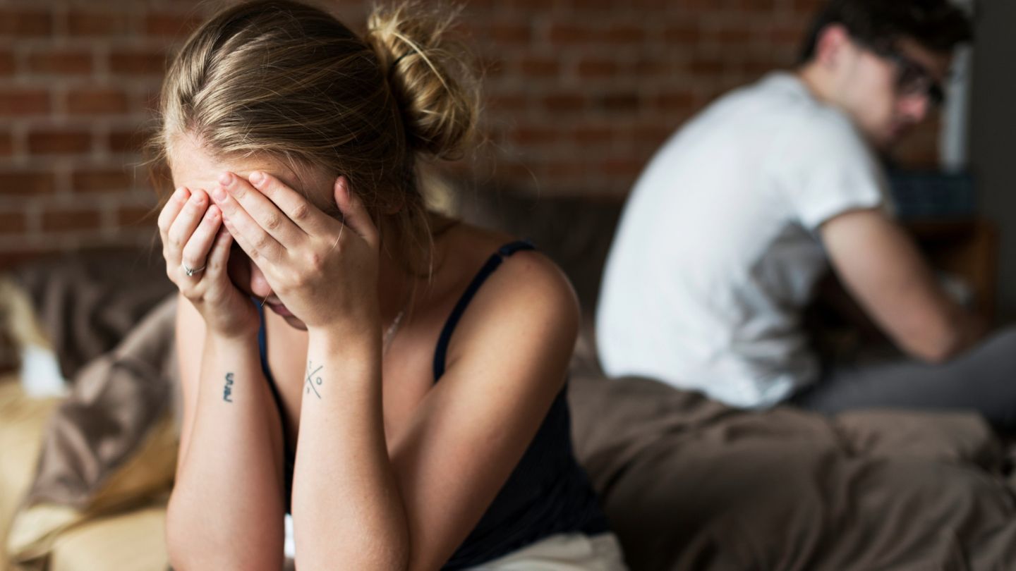 ein paar sitzt auf dem bett