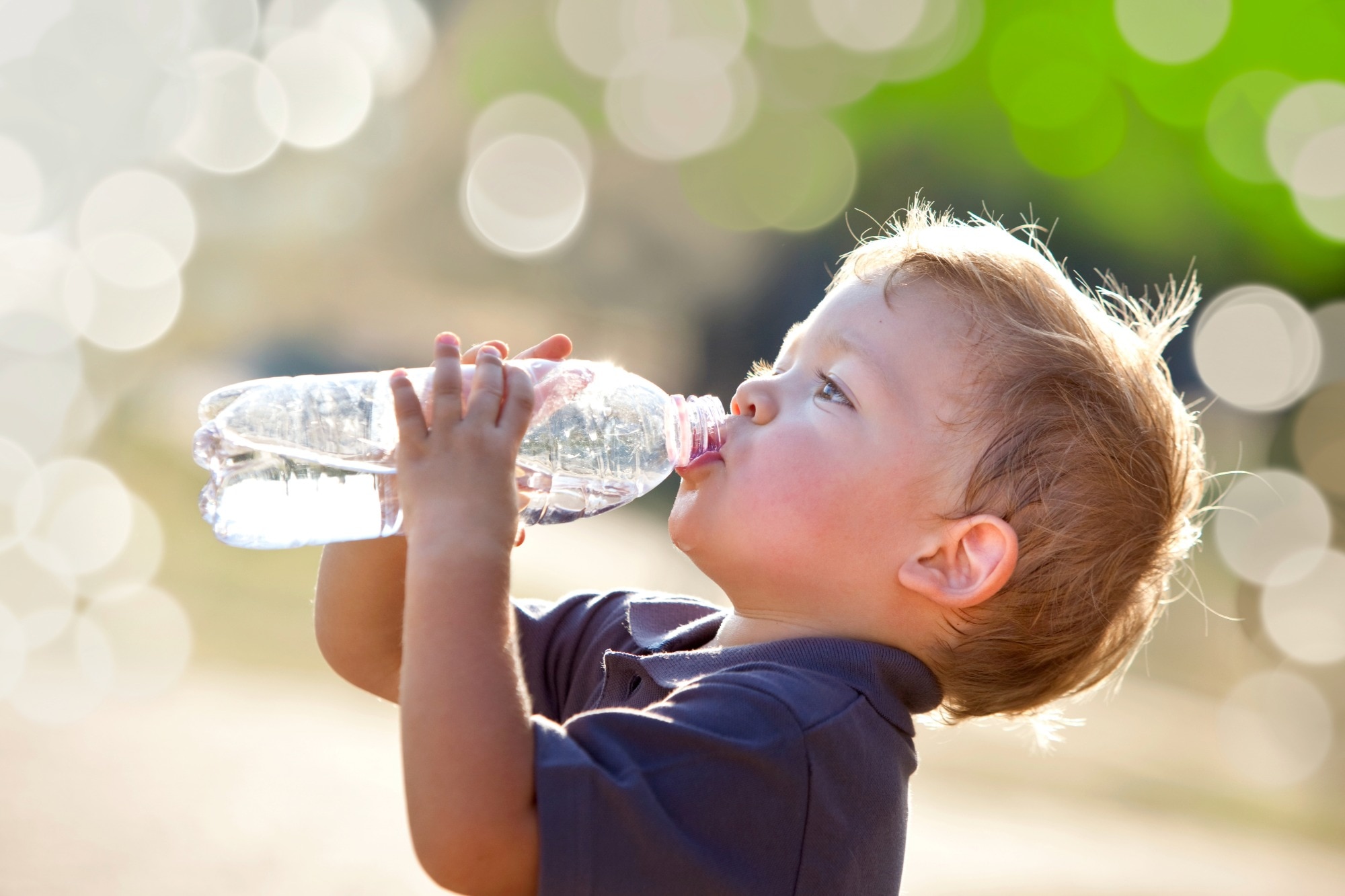 junge trinkt wasser aus einer flasche