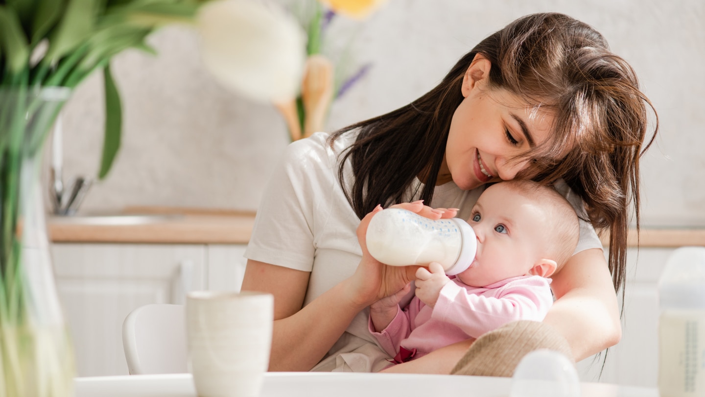 Mutter füttert Baby mit Fläschchen
