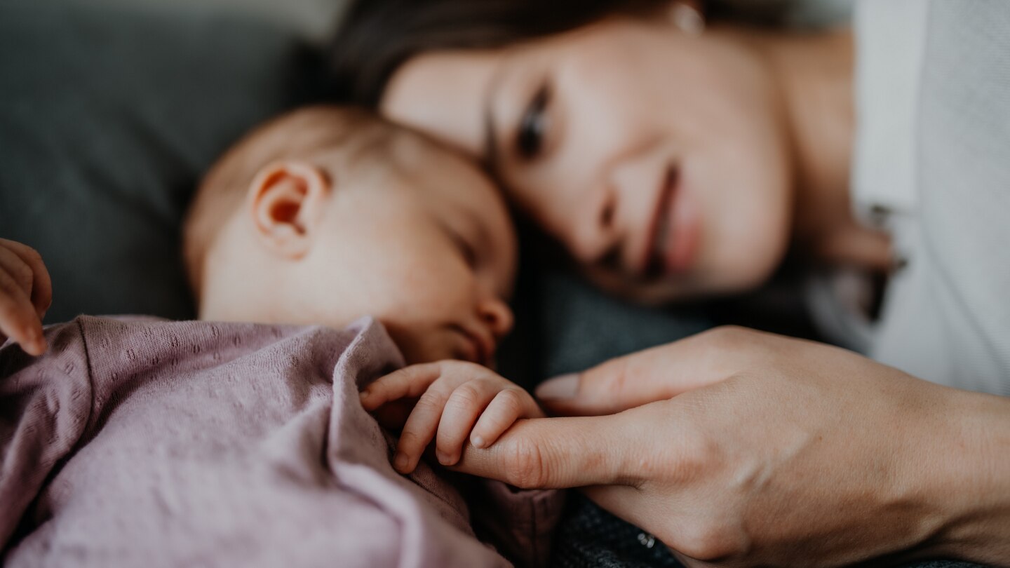 Mutter hält Babys Hand