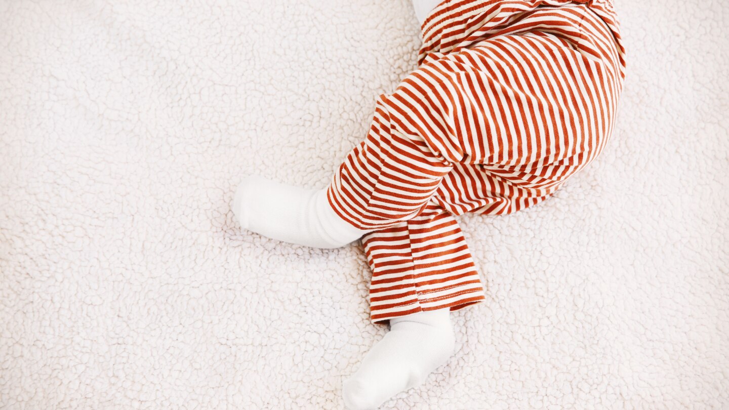 Cute little baby lying on plaid at home