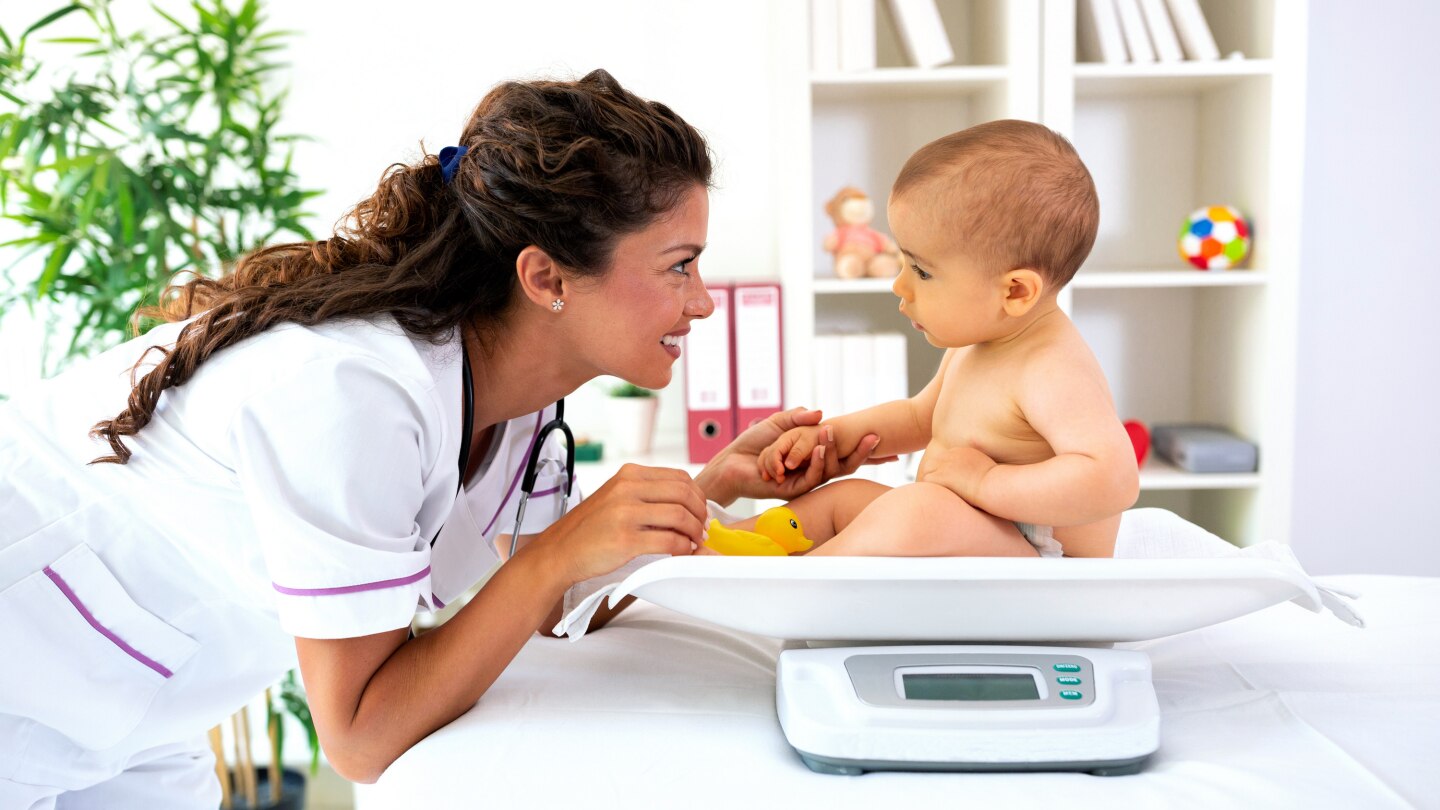 Baby beim Arzt auf der Waage