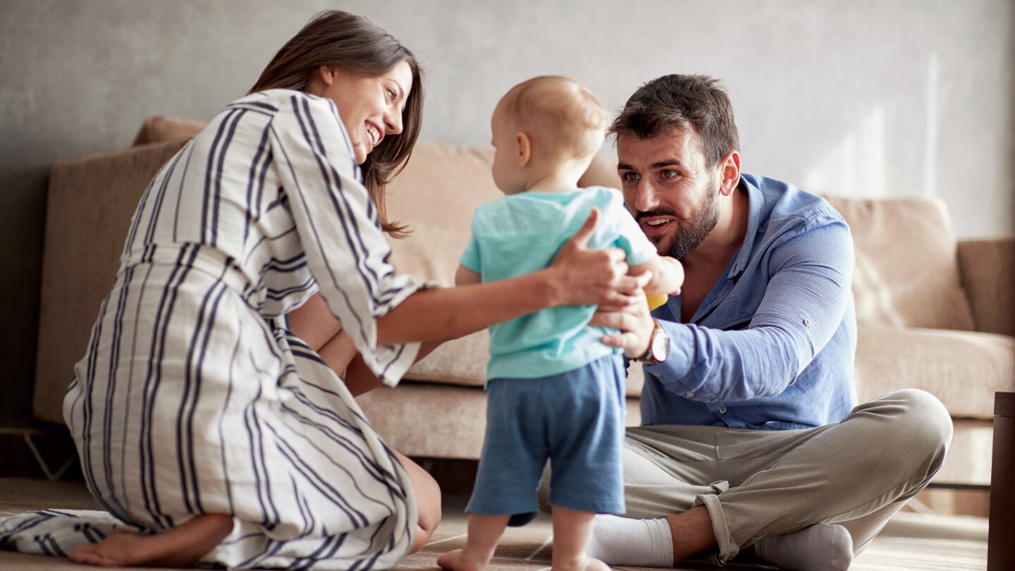 family is having fun playing with a baby at home