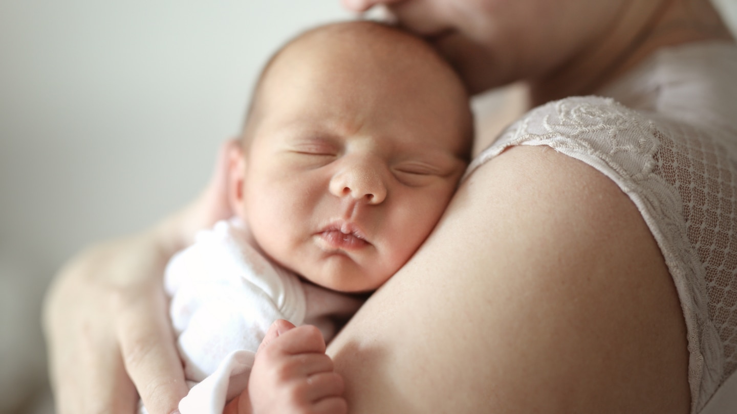 Baby schläft in Mamas Arm