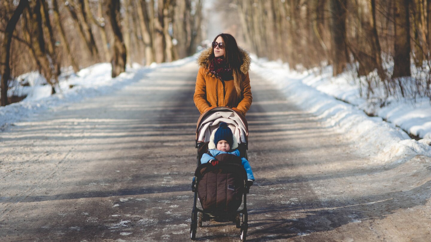 Mutter fährt den Kinderwagen