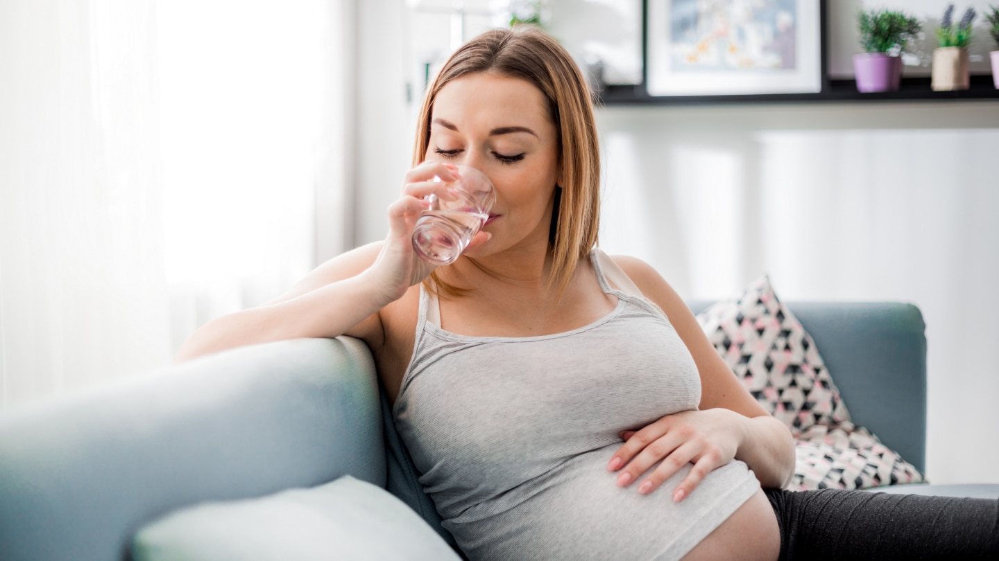 Schwangere trinkt Glas Wasser