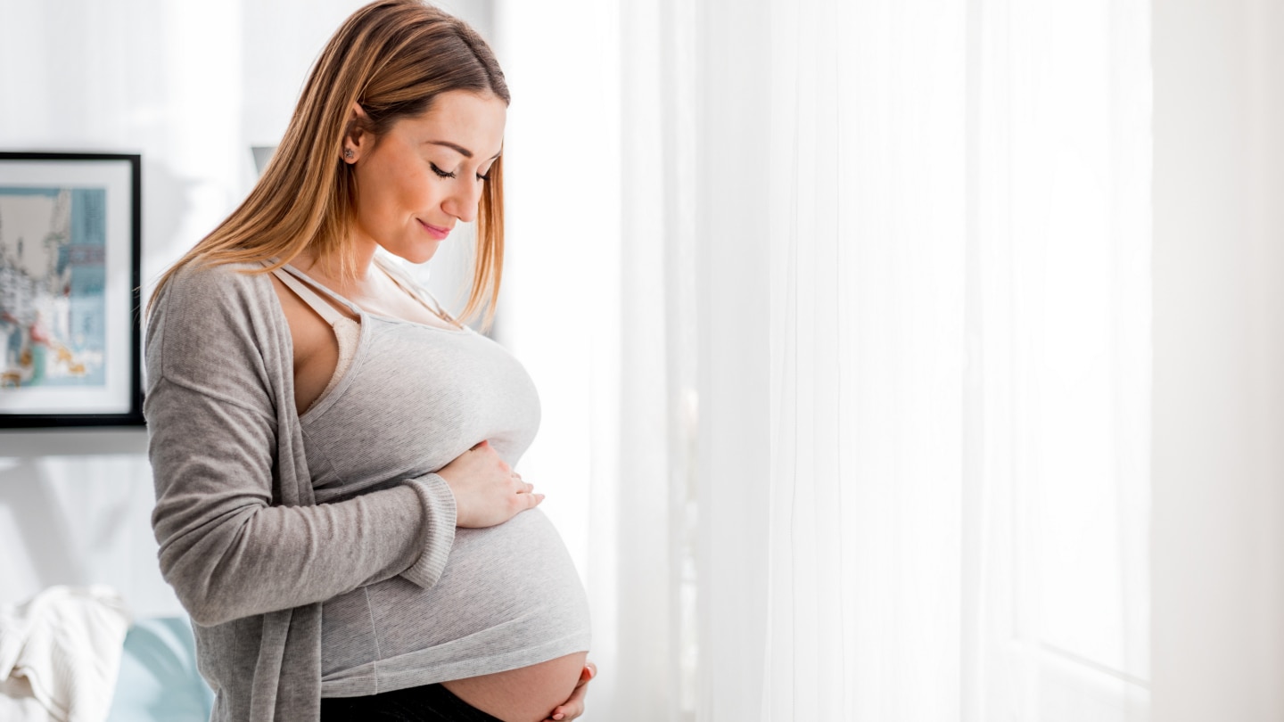 Beautiful pregnant woman touching her belly