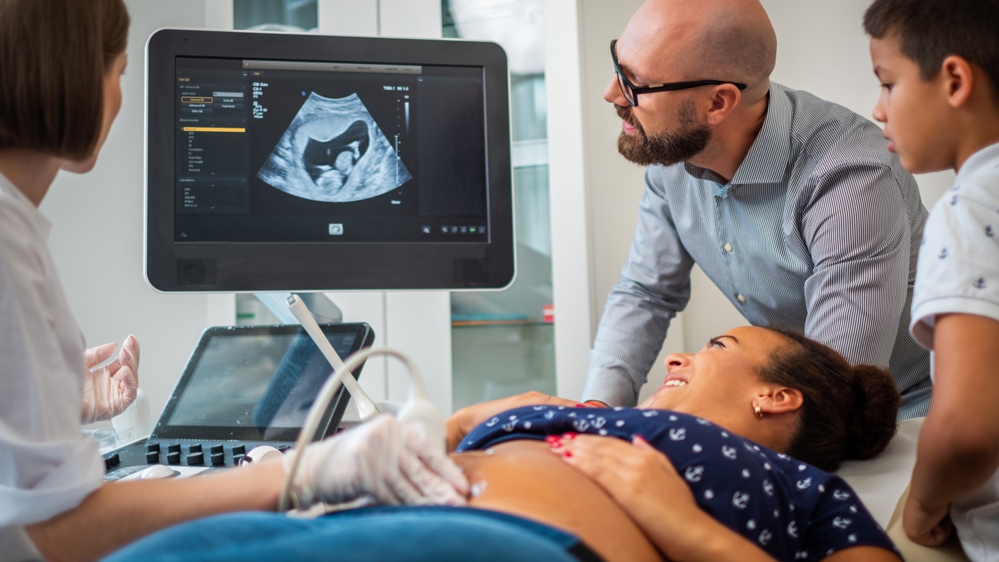 Pregnant woman and her family on utltrasonographic examination at hospital