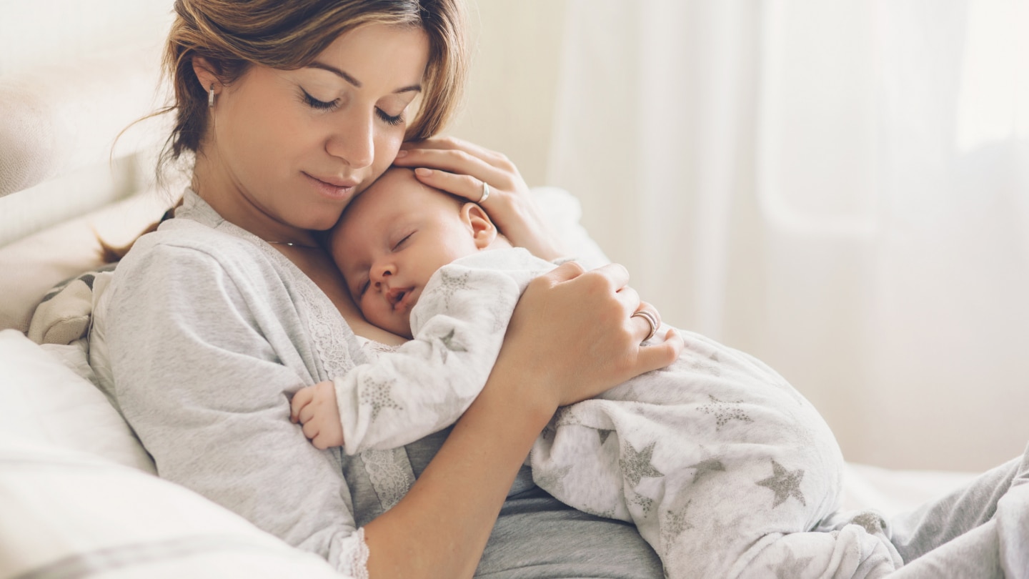 Baby schläft in Mamas Arm