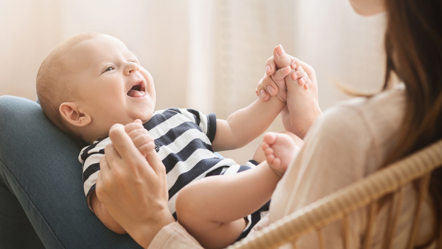 Portrait of sweet newborn child lying on mom's lap