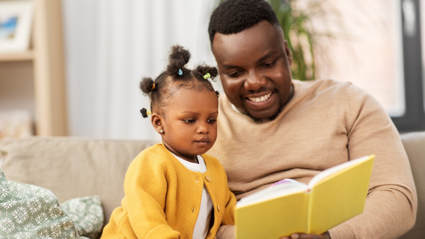 Vater liest Tochter aus dem Buch vor
