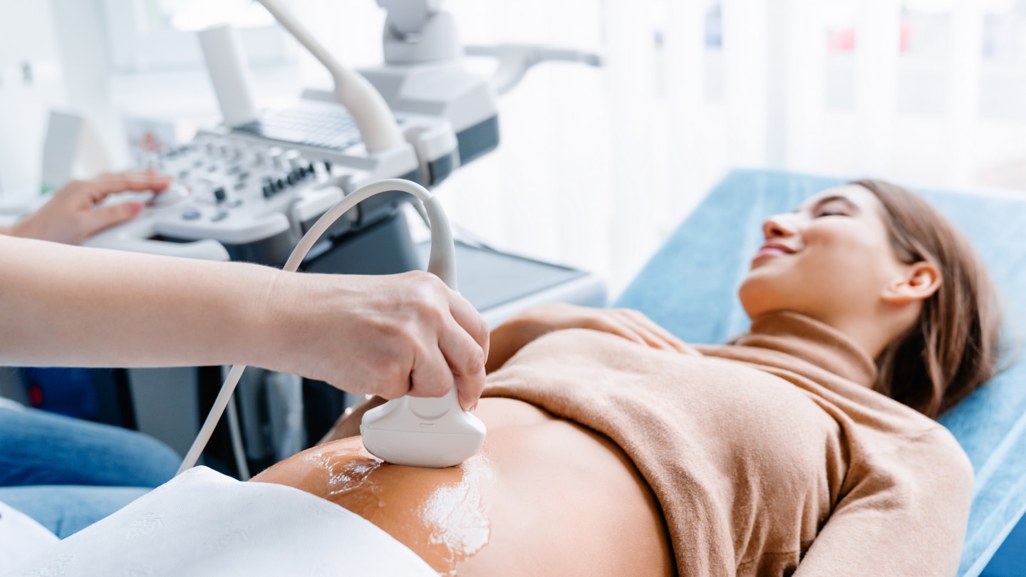Doctor hand with ultrasonic during ultrasound medicine examination of pregnant patient