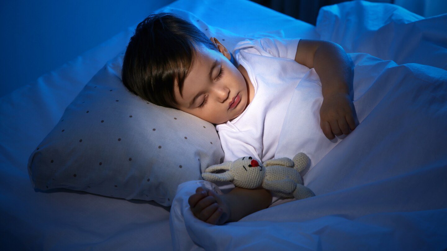 Cute little baby sleeping with toy at home. Bedtime