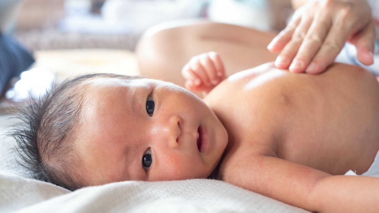 Close-up hands of mother touching and take care newborn infant baby