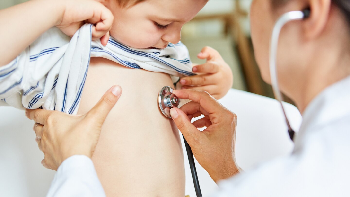 Kinderärztin beim Abhören von Lunge mit Stethoskop