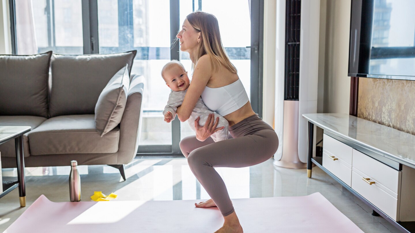 Mutter macht Sport mit Baby im Arm