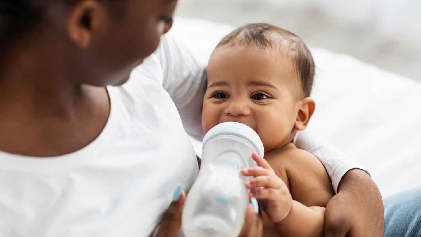 Mutter füttert ihr Baby mit dem Fläschchen