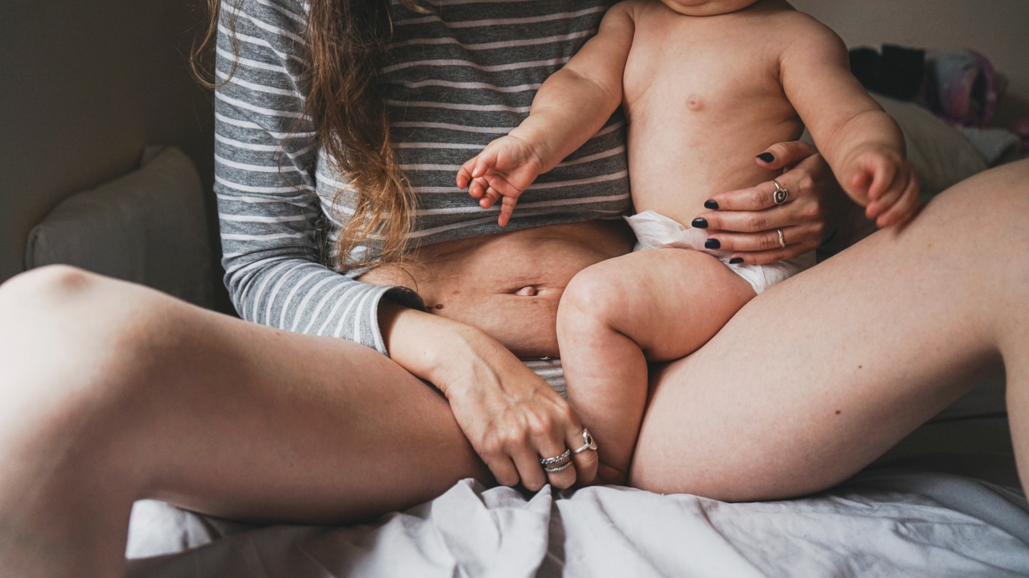 Mutter und Baby sitzen im Bett