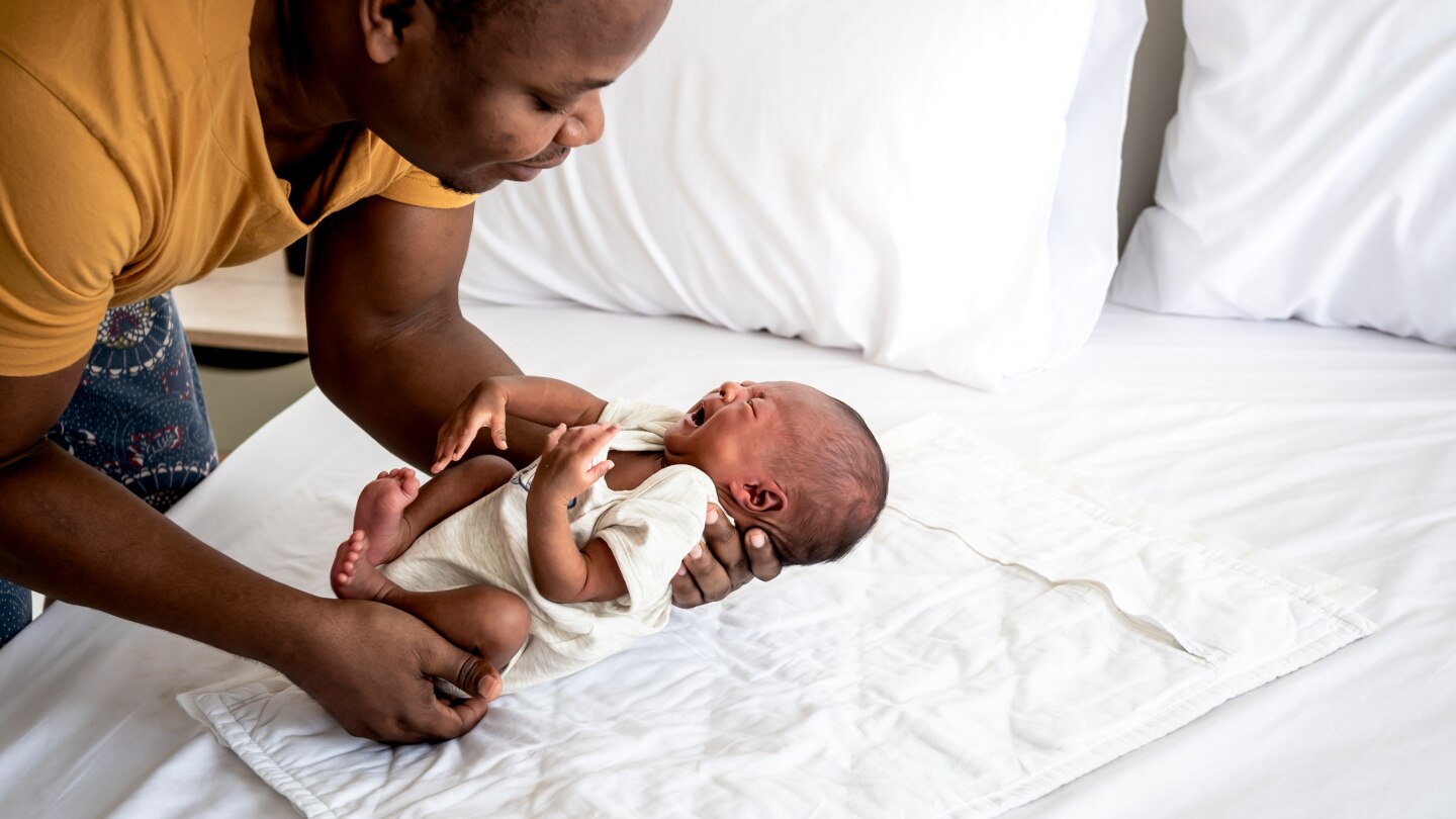 Vater hält schreiendes Baby in den Händen