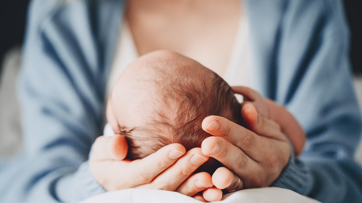 Frau hält den Kopf ihres Babys