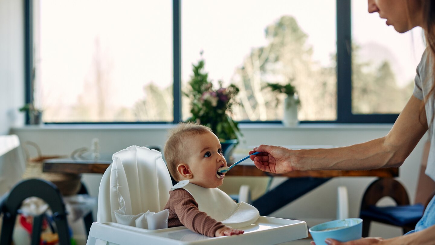Mother feeding her baby at home