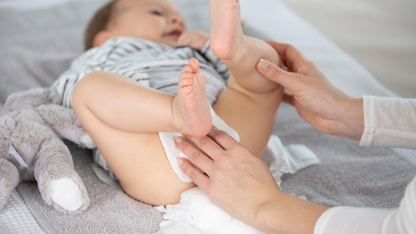 mother cleaning up her baby buttocks with wet hankies