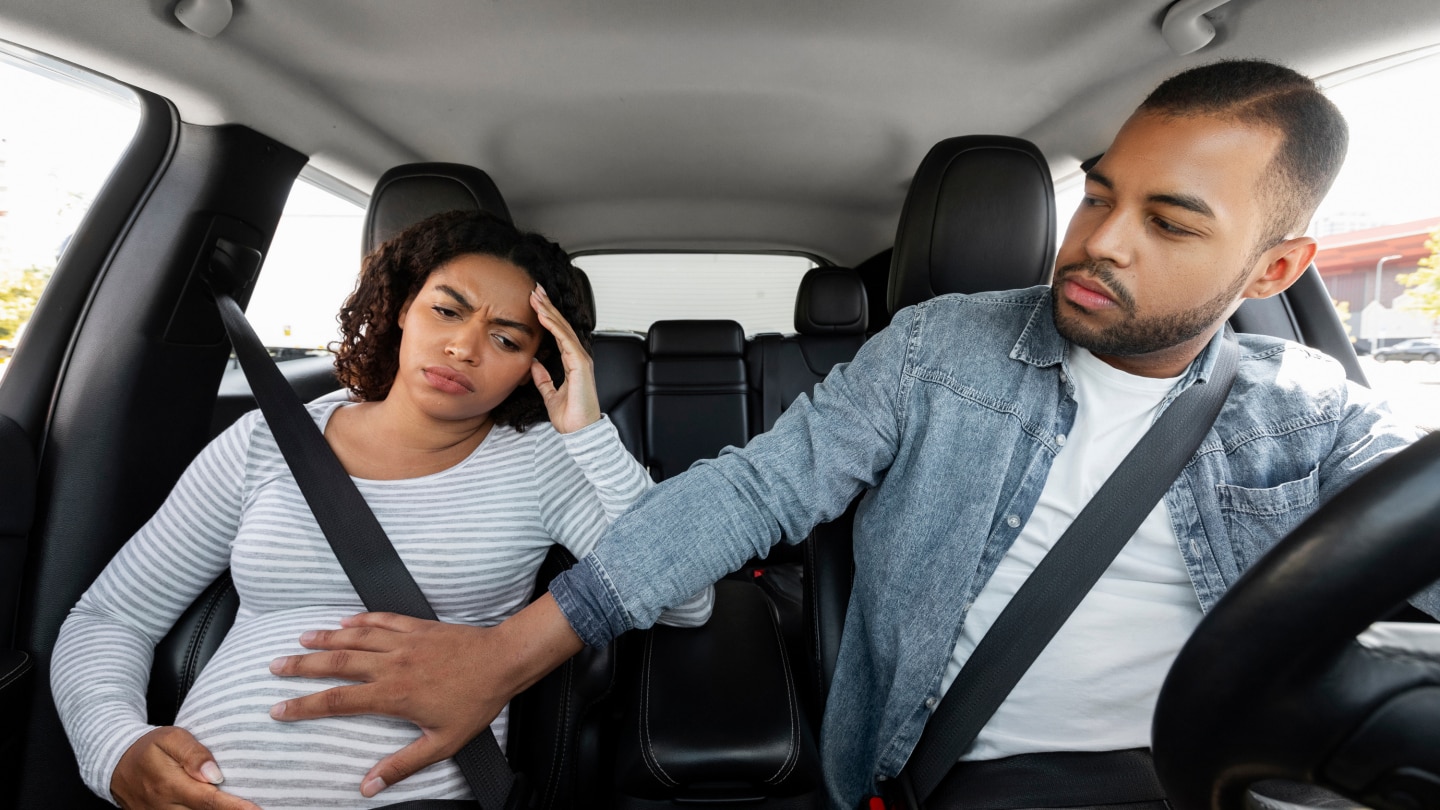 Young pregnant african american woman feeling pain in car