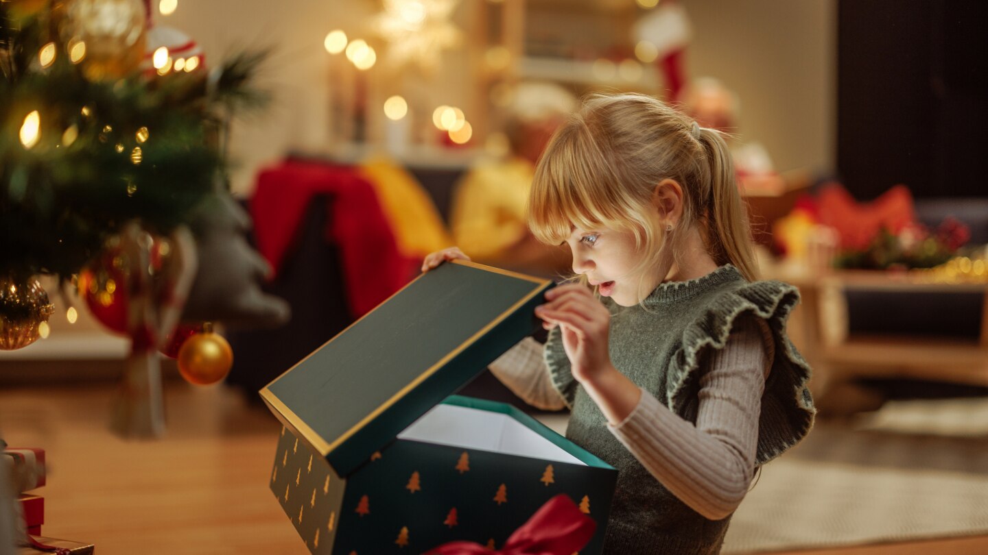 Little girl opening a mysterious Christmas present
