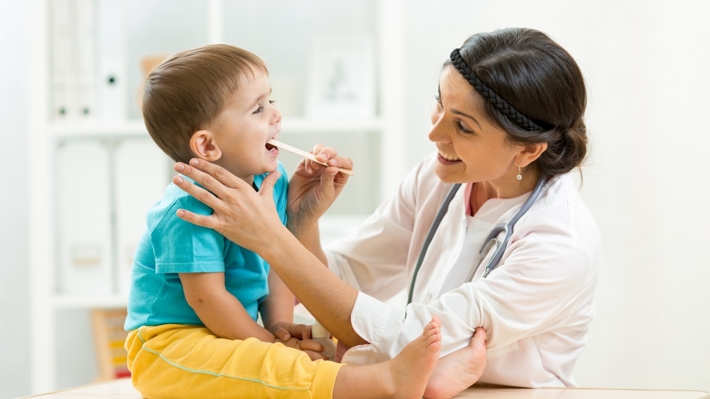 doctor examining little boy isolated on white background