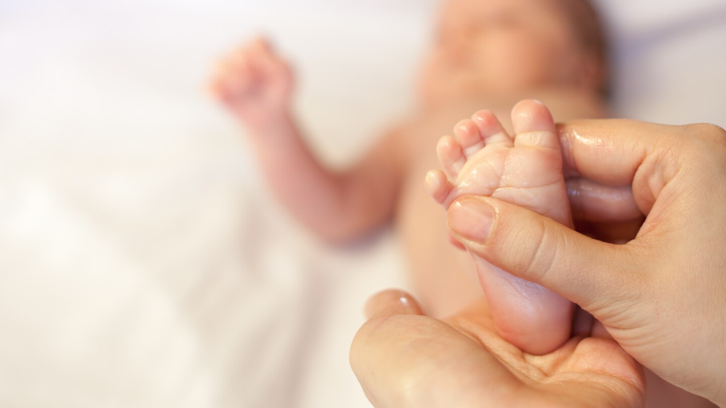 Mother makes massage for happy baby