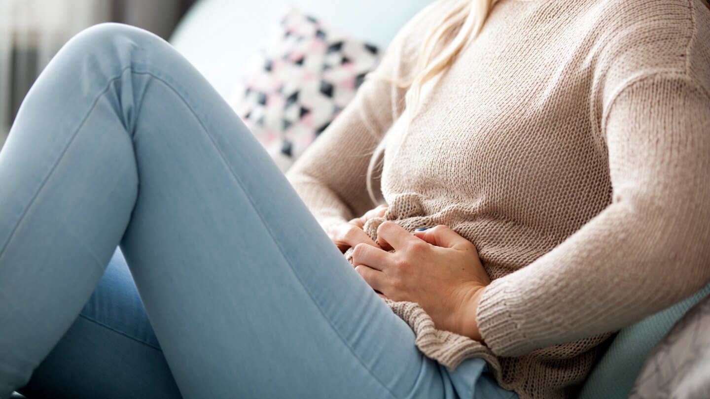frau hält sich den unterbauch vor schmerzen
