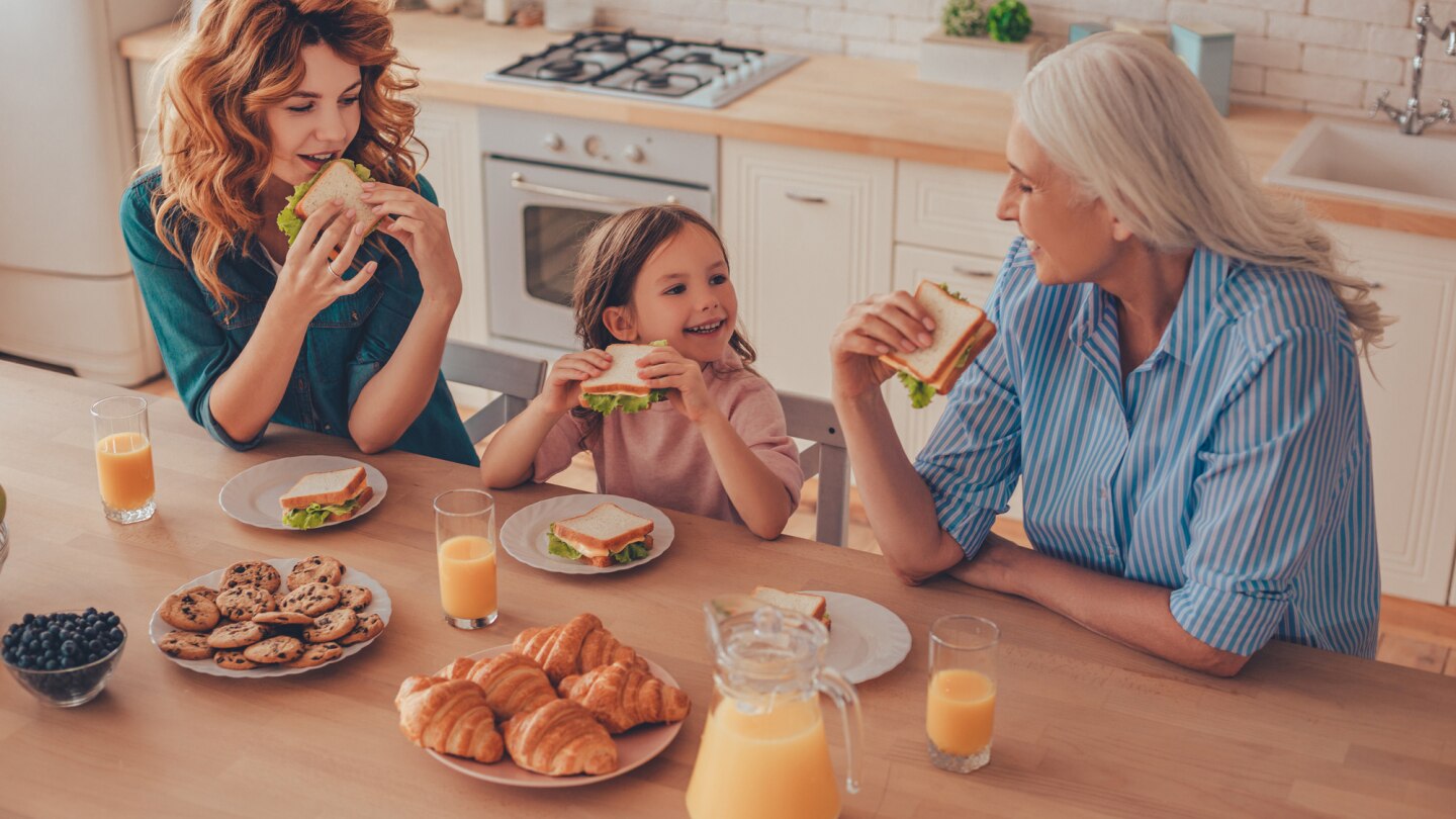 kind isst zusammen mit mutter und oma am tisch