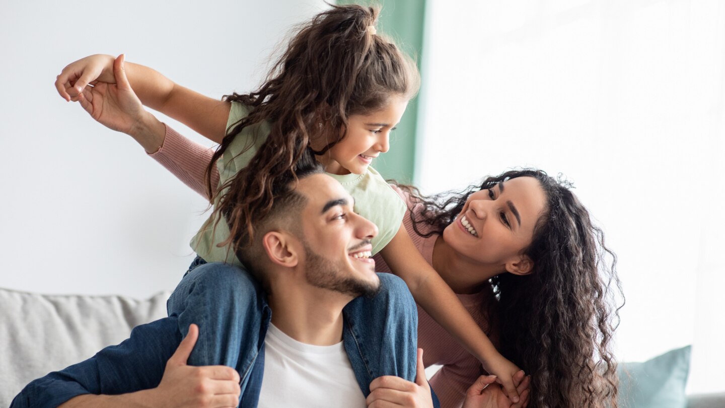 kind auf schultern vom vater, mutter neben dran