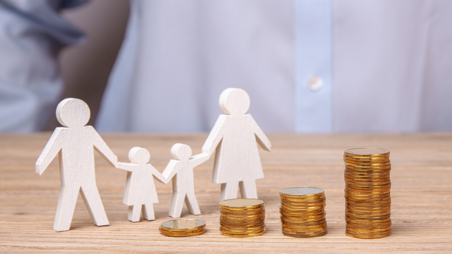 familien-pappfigur-und-münzstapel