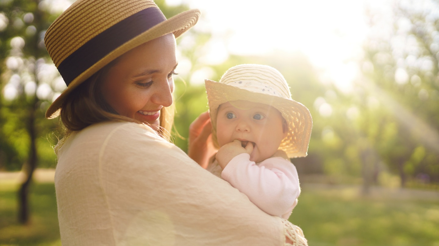 mutter-mit-baby-mit-sonnenhüten-im-sonnenschein