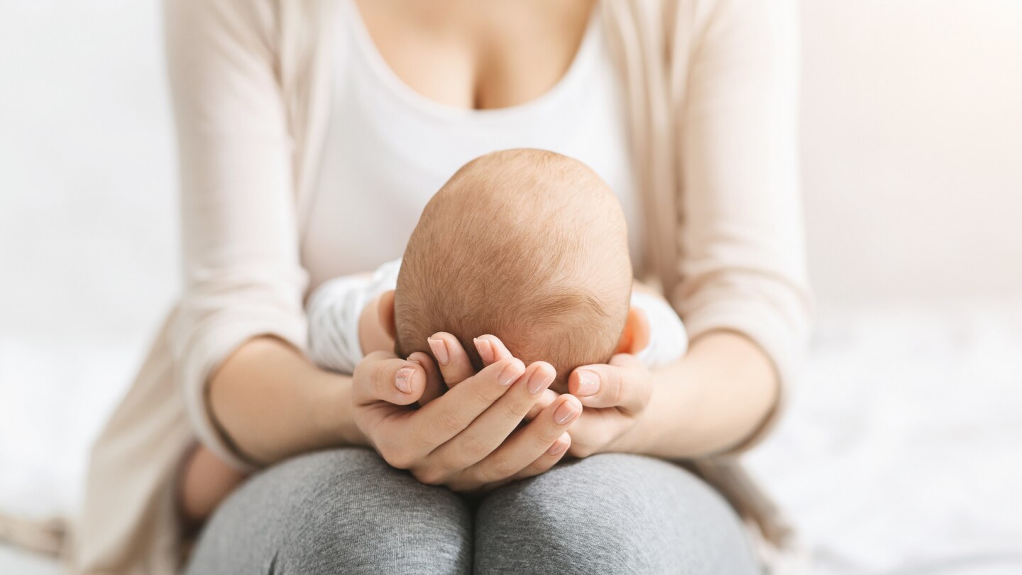 baby-liegt-auf-dem-schoß-der-mutter