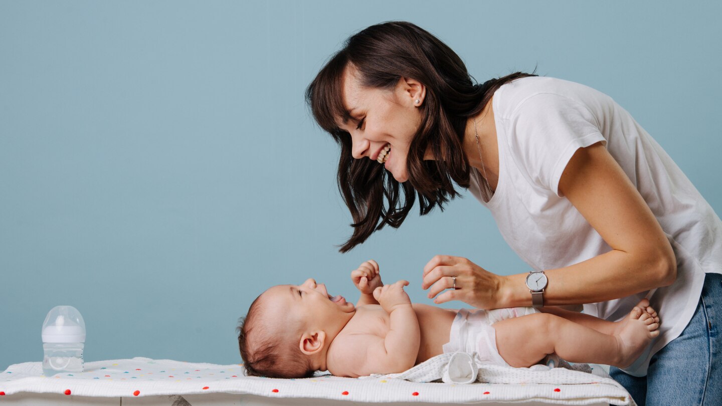 mutter-wickelt-baby-auf-wickeltisch