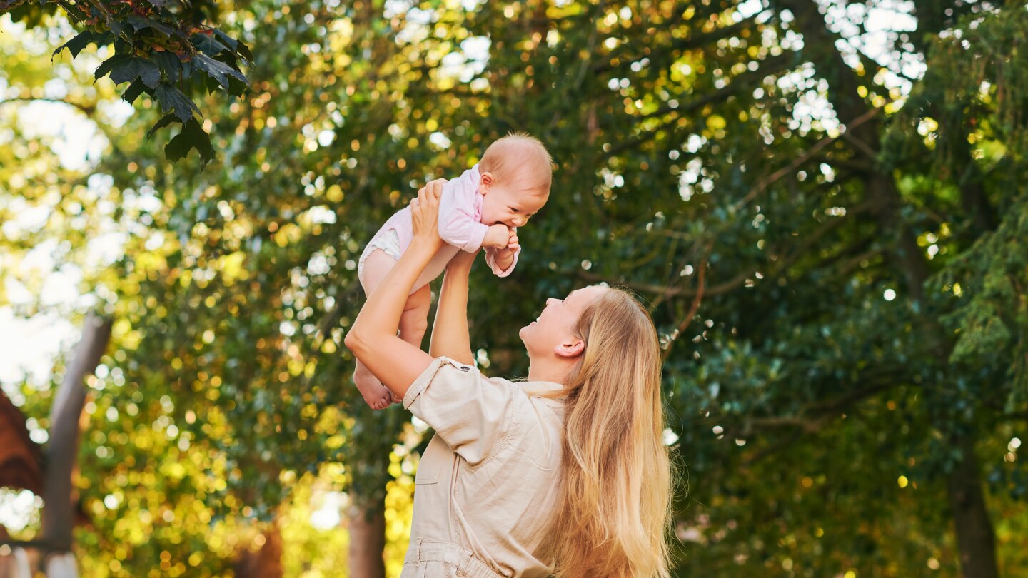 mutter-hebt-baby-in-die-luft