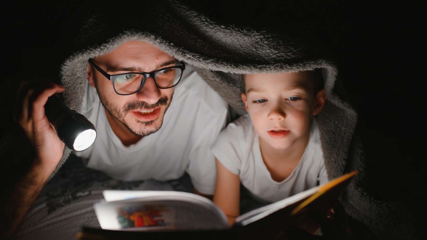 vater-und-sohn-lesen-unter-einer-decke