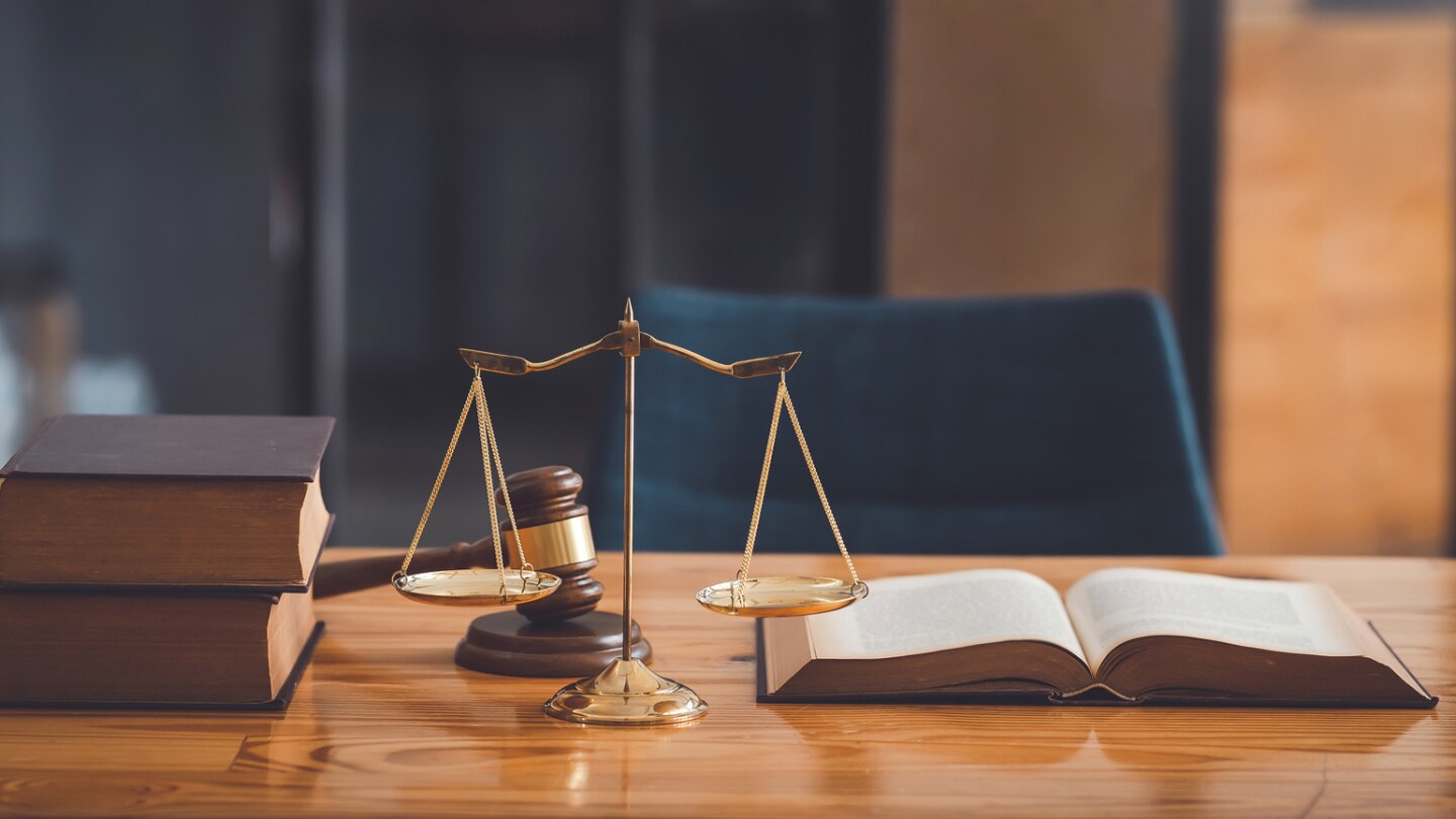 gesetzesbücher-und-waage-auf-holztisch